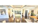 Open-concept great room featuring hardwood floors, columns, and tons of natural light at 4564 Investors Ln, Ellenwood, GA 30294