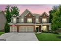 Beautiful brick and siding home with a three-car garage and well-manicured lawn at 4972 Park Vale Dr, Sugar Hill, GA 30518