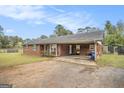 Charming brick home featuring a convenient carport and well-maintained landscaping at 1083 Hampton Rd, Hampton, GA 30228