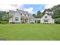 Beautiful two-story white farmhouse with lush lawn, covered porch and attached garage at 5187 Lower Fayetteville Rd, Sharpsburg, GA 30277