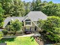 This charming home features a stone facade, manicured lawn, and mature trees at 324 Chimney Sweep Cir, Peachtree City, GA 30269