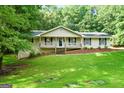 Inviting single-Gathering home with a charming front porch, complemented by a lush green lawn and mature trees at 185 Downybrook Ln, Fayetteville, GA 30215