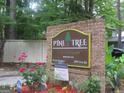 Pine Tree Condominiums brick signage surrounded by greenery and flowers at 101 Pinetree Trl, Atlanta, GA 30349