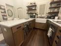 Bright kitchen featuring a farmhouse sink, a center island with bar stools, and open shelving with elegant decor at 155 Central Ave, Fayetteville, GA 30214
