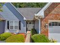 Inviting front entrance with a white door, surrounded by lush greenery and tasteful landscaping at 3511 Cherry Blossom Ct, Loganville, GA 30052