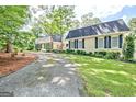 Spacious home with a long driveway, lush green lawn, and mature trees provides a welcoming approach at 522 Golfview, Peachtree City, GA 30269
