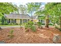 A well-maintained single-story home with black shutters and a well-manicured lawn, exudes curb appeal at 522 Golfview, Peachtree City, GA 30269