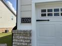 Close-up of the house number '13709' next to a white garage door with decorative windows at 13709 Whitman Ln, Covington, GA 30014