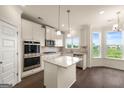 Bright kitchen with white cabinets, granite countertops, stainless steel appliances, and a center island at 13709 Whitman Ln, Covington, GA 30014