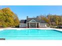 Inviting community pool with a clubhouse in the background, surrounded by lush greenery at 13709 Whitman Ln, Covington, GA 30014