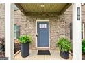 Inviting front entrance with gray door, brick facade, and potted ferns at 209 Osier Dr, Mcdonough, GA 30252