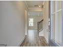 Inviting foyer with hardwood floors, staircase, and view into the living area with coffered ceilings at 402 Westmarch Cir # 285A, Loganville, GA 30052