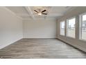 Bright living room with coffered ceiling, large windows, and hardwood floors at 402 Westmarch Cir # 285A, Loganville, GA 30052