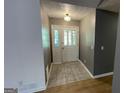 Foyer showcasing a light fixture and white front door with detailed tile flooring, radiating a bright welcome at 4710 Cedar Brook Se Dr, Conyers, GA 30094