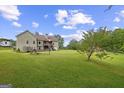 Expansive backyard with a gentle slope, lush green grass, mature trees and patio at 9360 Ward Rd, Winston, GA 30187