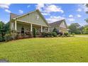 Exterior shot of a home with green siding and a spacious, well-manicured front lawn at 9360 Ward Rd, Winston, GA 30187