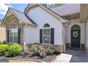Beautiful entryway featuring a decorative door with a floral wreath and landscaped flower bed at 170 Saddleridge Dr, Bremen, GA 30110