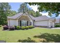Beautifully landscaped front yard featuring a well-maintained lawn, shrubs, and exterior stone accents at 170 Saddleridge Dr, Bremen, GA 30110