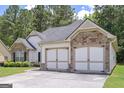 Side view of a two-car garage with stone accents matching the house, plus ample driveway parking at 170 Saddleridge Dr, Bremen, GA 30110