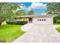 Charming single-story home featuring lush landscaping, driveway, and an attached three-car garage at 741 Greenhill Ne Dr, Conyers, GA 30012