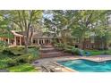 Gorgeous backyard features a sparkling pool, multi-tiered patio, and lush landscaping, perfect for entertaining at 115 Shoal Creek Dr, Sharpsburg, GA 30277