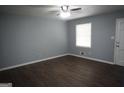 Bright bedroom with hardwood floors, a ceiling fan, and a large window that allows natural light at 39 Mcferrin Cir, Riverdale, GA 30274