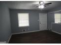 Bright living room with hardwood floors, a ceiling fan, and a large window that allows natural light at 39 Mcferrin Cir, Riverdale, GA 30274