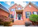 Close up of the brick front of an elegant home with decorative shutters and an American flag at 713 Birkdale Blvd, Carrollton, GA 30116