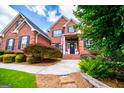 Inviting brick home featuring a landscaped front yard with a beautiful walkway to the front door at 713 Birkdale Blvd, Carrollton, GA 30116