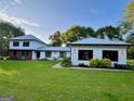 Charming home with lush green lawn, beautiful landscaping, and a metal roof at 360 Morgan Mill Rd, Brooks, GA 30205