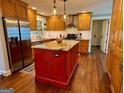 Spacious kitchen features a red island with a granite countertop, stainless steel appliances, and wooden cabinetry at 360 Morgan Mill Rd, Brooks, GA 30205