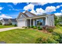 Beautifully landscaped front yard with lush grass, shrubs, and a charming single-story home at 326 Elkins Pl, Peachtree City, GA 30269