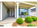 Inviting front porch with seating area, perfect for enjoying the outdoors with decorative blue shutters at 326 Elkins Pl, Peachtree City, GA 30269