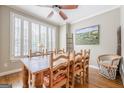Bright dining room featuring a large wooden table with seating, hardwood floors, and shuttered windows at 3502 Village Green Dr, Roswell, GA 30075