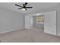 Spacious bedroom with a ceiling fan and view to another room with lots of light from the windows at 115 Rockhurst Chase, Tyrone, GA 30290