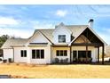 The back of a home with a covered porch, featuring a dining area and a seating area at 25 Oak Rd, Locust Grove, GA 30248