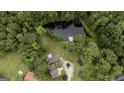 Aerial view of home, pond, green grass and many mature trees at 300 Peggy Cole Bridge Rd, Villa Rica, GA 30180