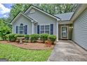 Close up of front lawn and bushes of a single story home with lovely green foliage at 40 Riverside Pkwy, Sharpsburg, GA 30277