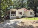 Cozy single-story home featuring a red roof, spacious porch, and natural surroundings with mature shade trees at 2306 Old Lower River Rd, Douglasville, GA 30135