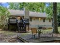 Backyard view featuring a wooden deck with stairs, mature trees, and an outdoor seating area at 1624 Hampton Locust Grove Rd, Locust Grove, GA 30248