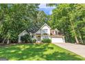 Charming two-story home featuring a well-manicured lawn and lush trees at 105 Rosewood Cir, Covington, GA 30016