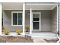 Inviting covered front porch adorned with potted flowers, offering a cozy entrance with a well-maintained door and accents at 2069 Countydown Ln, Stone Mountain, GA 30088