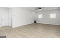 Spacious living room with wood-look floors, a ceiling fan, and large windows at 82 Cantrell Drive, Dallas, GA 30157