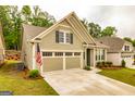 Home exterior featuring an attached two-car garage, well-maintained lawn, and an American flag at 444 Silverbell Ct, Peachtree City, GA 30269
