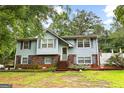 Charming two-story home with light blue siding, brick accents, and a lush green lawn at 201 Greensprings Dr, Palmetto, GA 30268