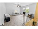 Bright living room with neutral carpet, a ceiling fan, and a staircase at 201 Greensprings Dr, Palmetto, GA 30268