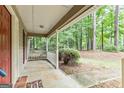 A covered front porch featuring white railings and columns offers a shaded spot to relax at 215 Longwood Dr, Jonesboro, GA 30236