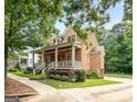 Angle view of brick home featuring a spacious front porch and manicured yard at 5130 Pratt Sw St, Covington, GA 30014