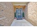 Inviting front door with sidelights, potted greenery, and brick facade creating a warm entrance at 260 Bonnie Ln, Fayetteville, GA 30215