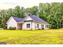 Beautiful home featuring white siding, a dark roof, and a lush green lawn at 40 Westbrook Rd, Carrollton, GA 30116